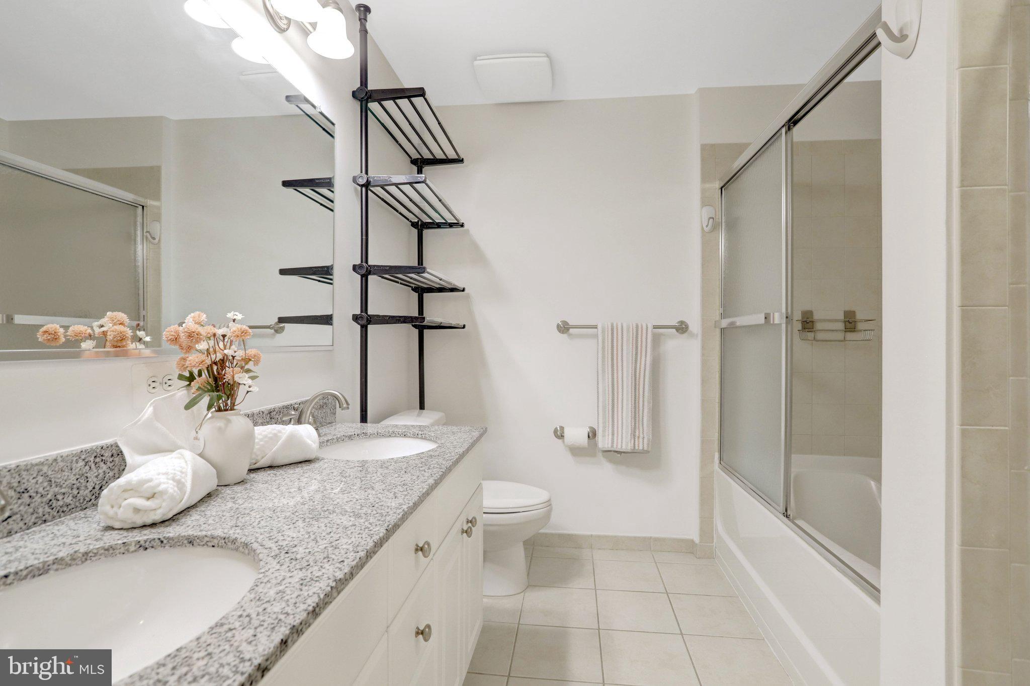 3650 South Glebe Road, Unit 442 Arlington, VA 22202 - Photo 33 of 54 a bathroom with a granite countertop sink a toilet and shower