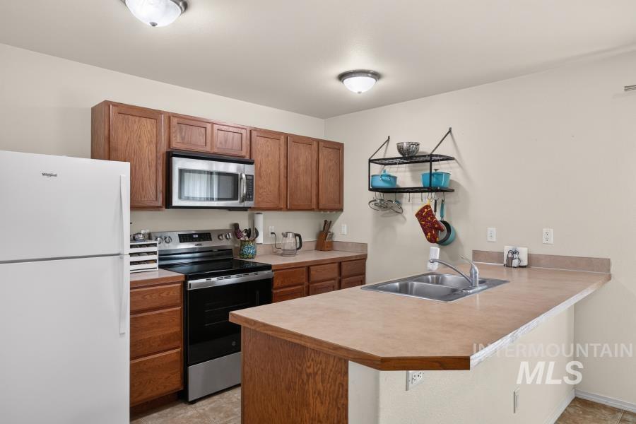 1337 Bristol Road Moscow, ID 83843 - Photo 11 of 28 Kitchen with wood-finish cabinetry, stainless steel microwave, and white refrigerator