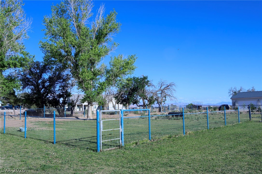 2775 Taylor Street Logandale, NV 89021 - Photo 37 of 41 Expansive yard with mature trees and mountain views, offering ample space and serene surroundings.