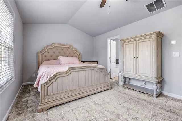 a bedroom with a white bed and a window