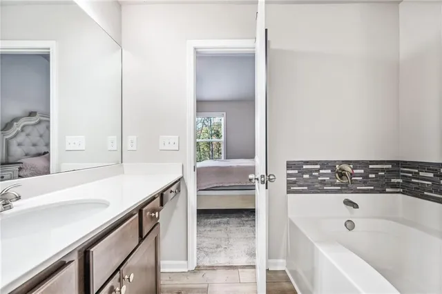 a bathroom with a tub sink and mirror