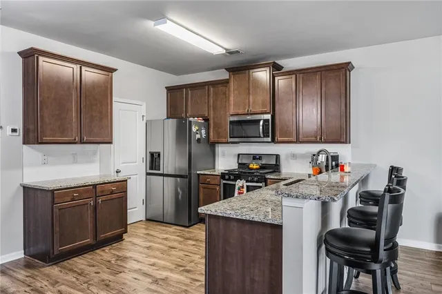 a kitchen with a sink a microwave a refrigerator and wooden cabinets