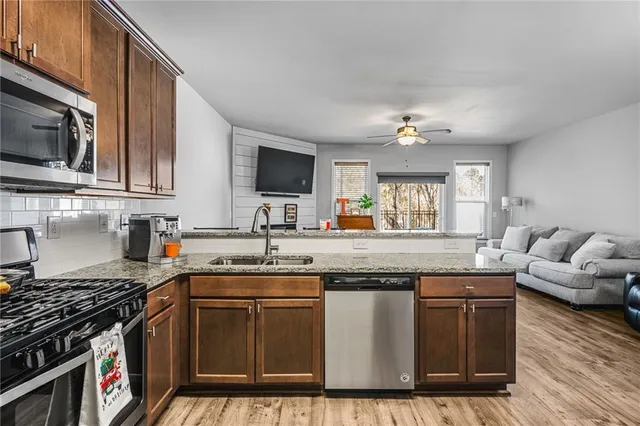 a kitchen with stainless steel appliances granite countertop a stove a sink and a microwave