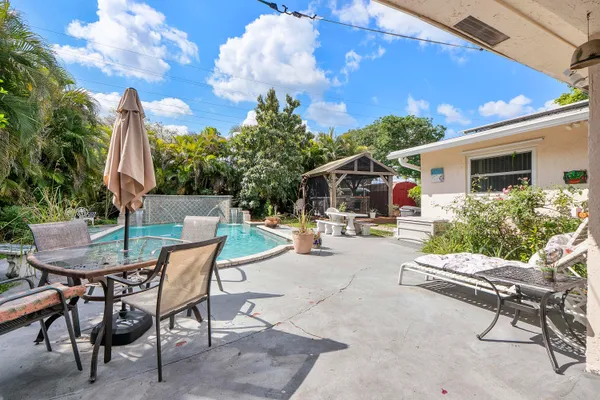 a view of swimming pool with lawn chairs and a yard