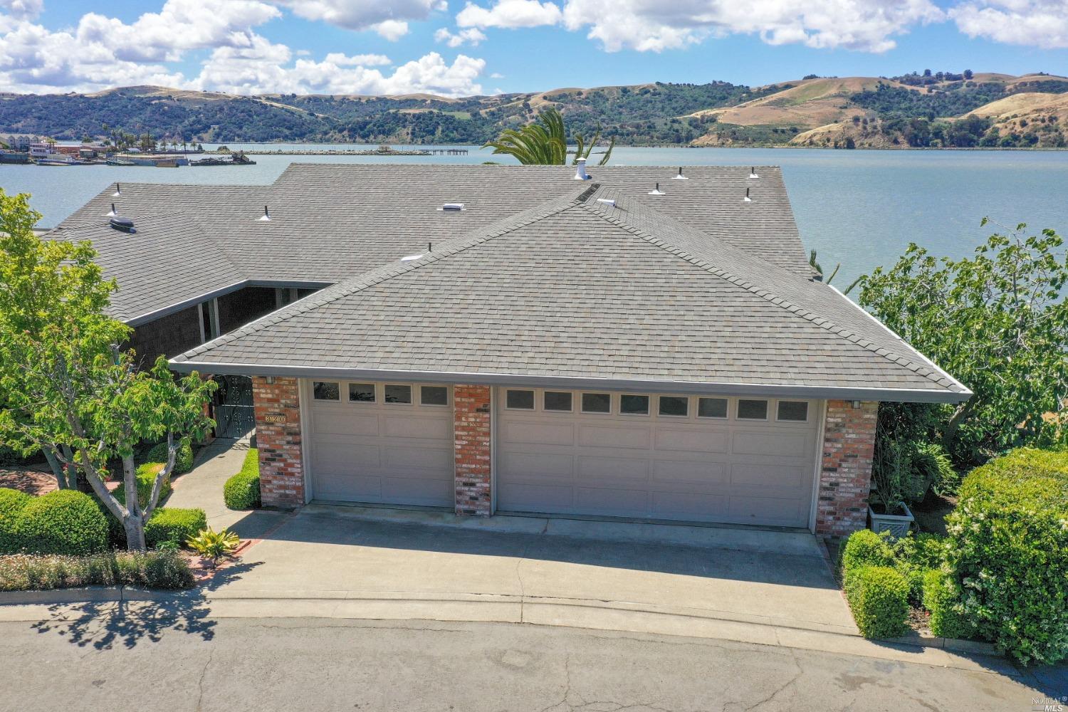an aerial view of a house with a yard and ocean view