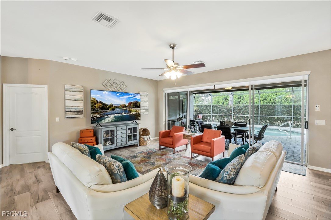 15047 Balmoral Loop Fort Myers, FL 33919 - Photo 16 of 37 a living room with furniture a flat screen tv and a large window