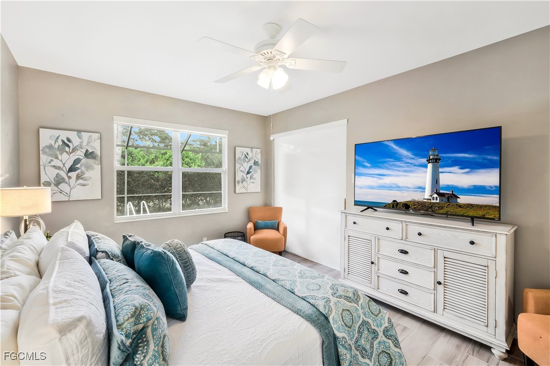 15047 Balmoral Loop Fort Myers, FL 33919 - Photo 17 of 37 a bedroom with a large bed and a flat tv screen on dresser