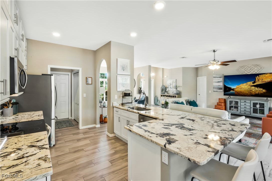 15047 Balmoral Loop Fort Myers, FL 33919 - Photo 9 of 37 a large kitchen with kitchen island a sink stove and refrigerator