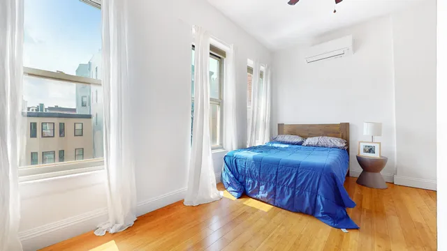 a bedroom with a bed and a painting on the wall