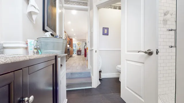 a bathroom with a granite countertop sink a toilet and a mirror