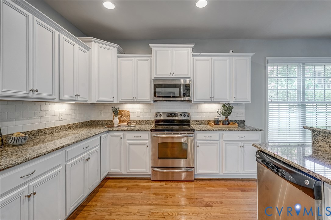 3612 Edenfield Road Midlothian, VA 23113 - Photo 11 of 50 a kitchen with stainless steel appliances granite countertop a stove a sink and white cabinets