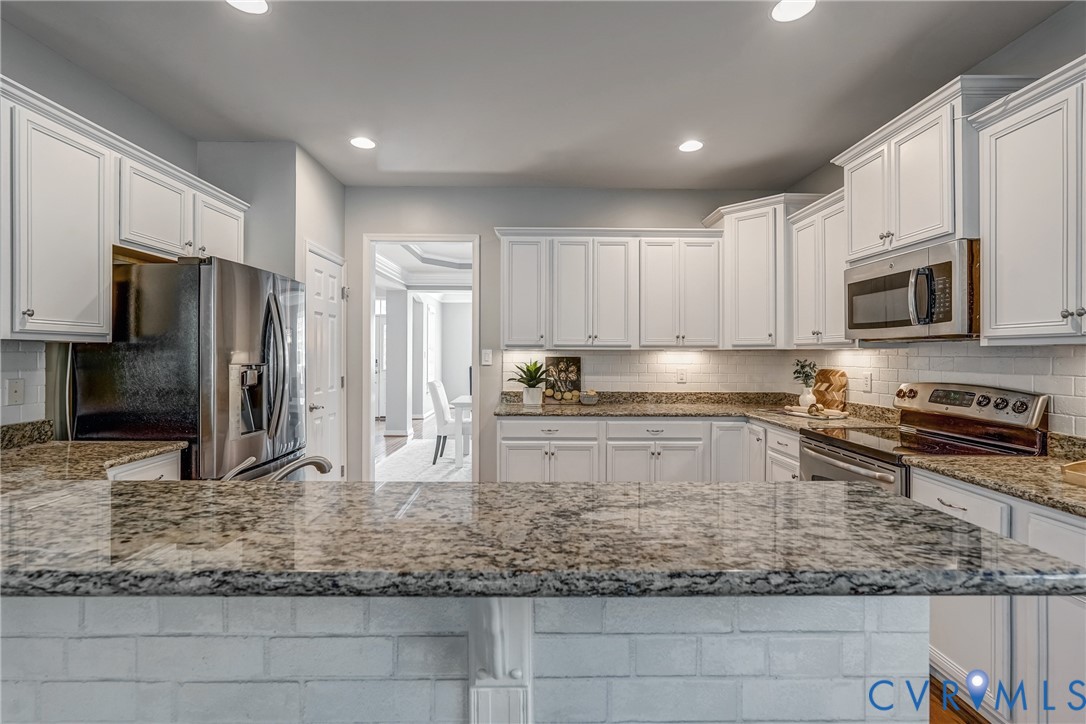 3612 Edenfield Road Midlothian, VA 23113 - Photo 12 of 50 a kitchen with stainless steel appliances granite countertop a stove a sink a microwave and a refrigerator