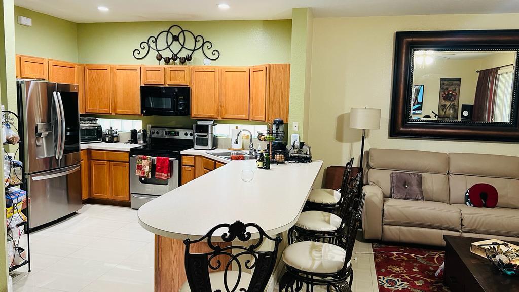 1267 Rose Gate Boulevard Riviera Beach, FL 33404 - Photo 13 of 29 a kitchen with stainless steel appliances a microwave a stove and refrigerator