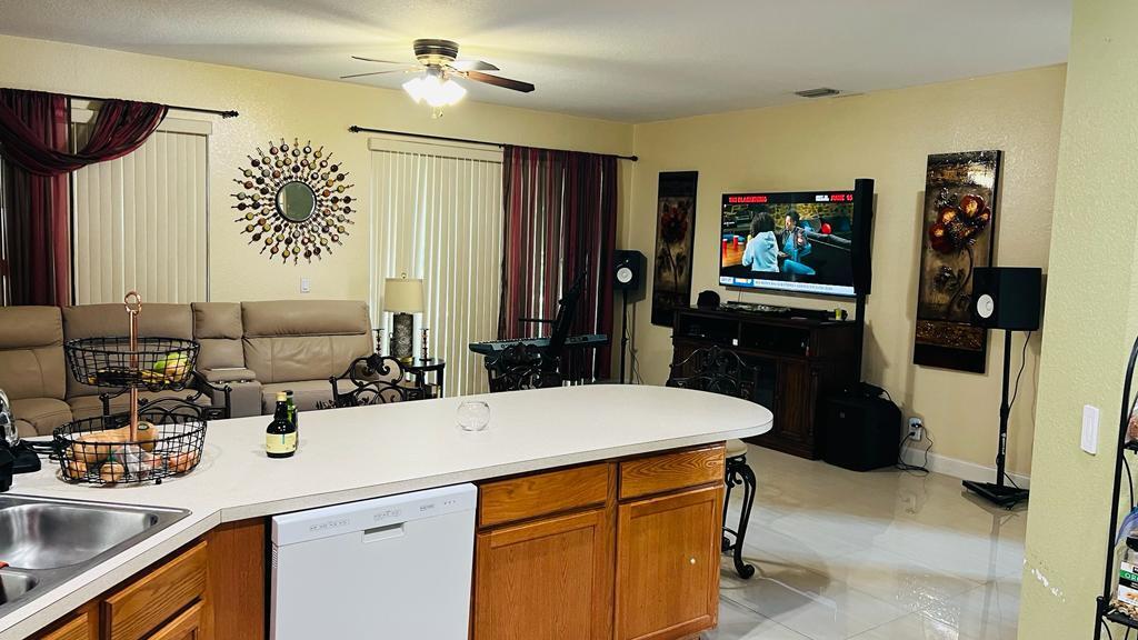 1267 Rose Gate Boulevard Riviera Beach, FL 33404 - Photo 14 of 29 a kitchen with a sink and a refrigerator