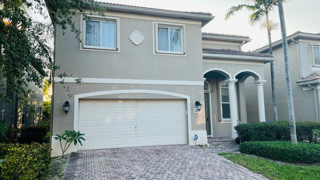 1267 Rose Gate Boulevard Riviera Beach, FL 33404 - Photo 2 of 29 a front view of a house with garden