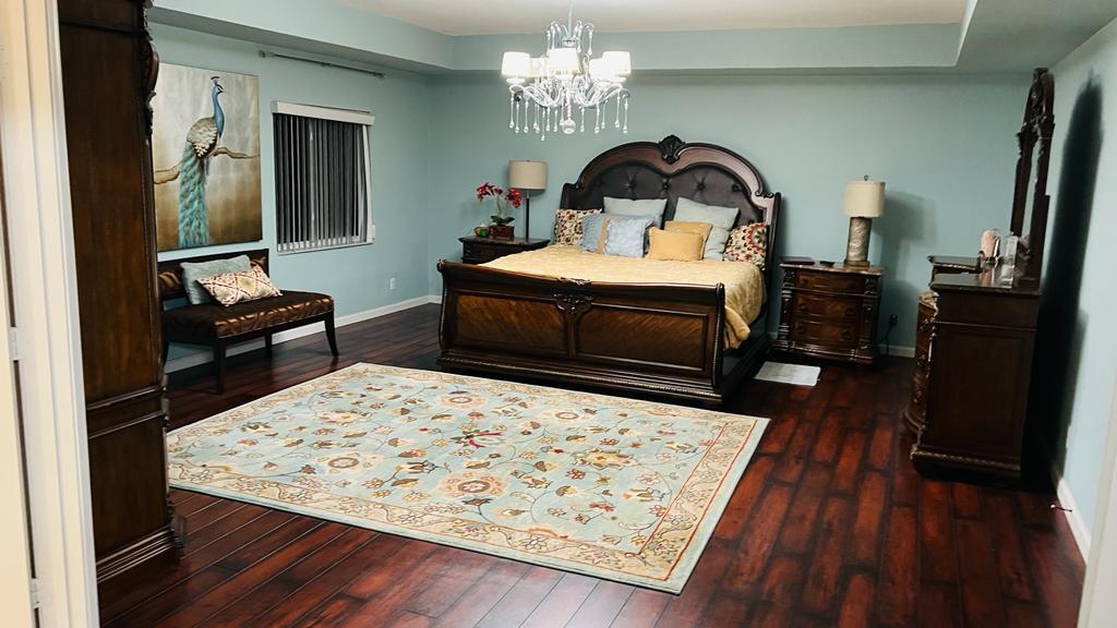 1267 Rose Gate Boulevard Riviera Beach, FL 33404 - Photo 21 of 29 a bedroom with a bed and a dresser with mirror