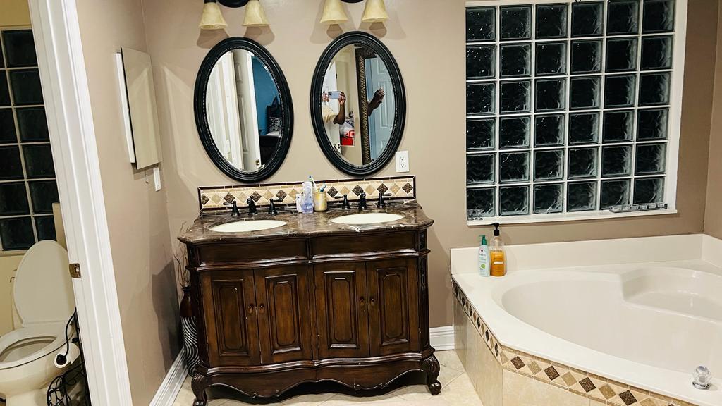 1267 Rose Gate Boulevard Riviera Beach, FL 33404 - Photo 28 of 29 a bathroom with a sink a mirror and a bathtub