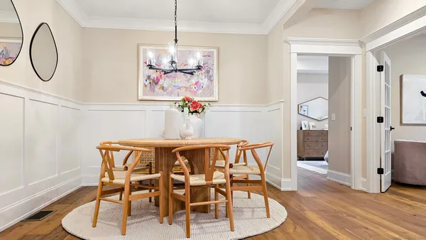 a dining room with wooden floor a glass table and chairs