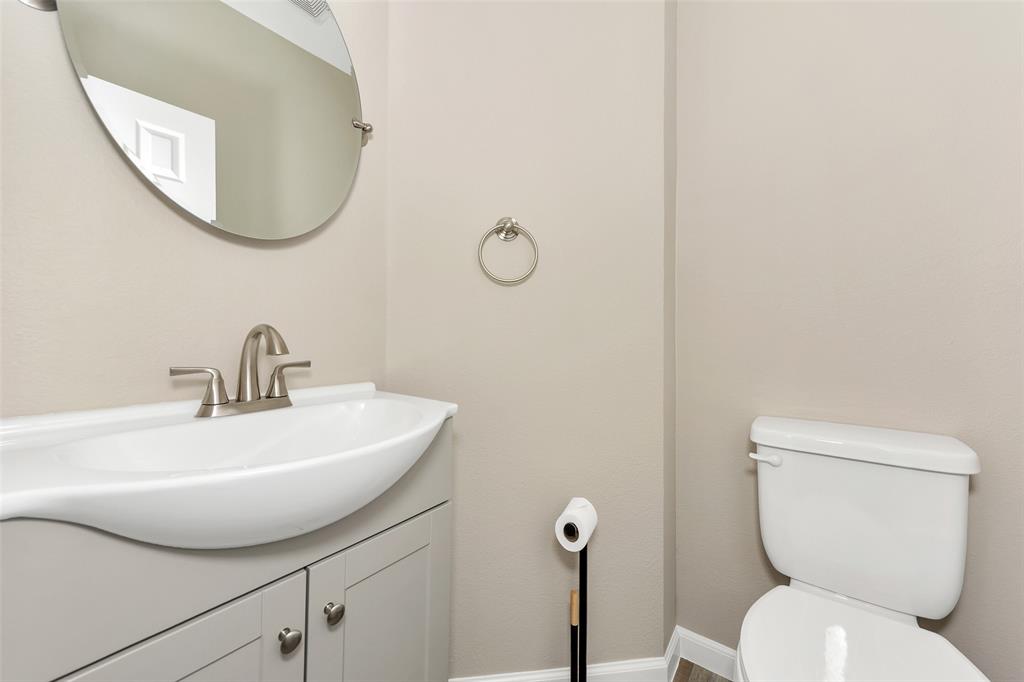 857 Summit Pointe Lewisville, TX 75077 - Photo 17 of 33 a bathroom with a toilet a sink and mirror