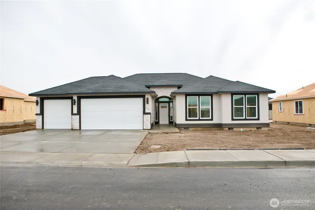 a front view of a house with a garden and yard