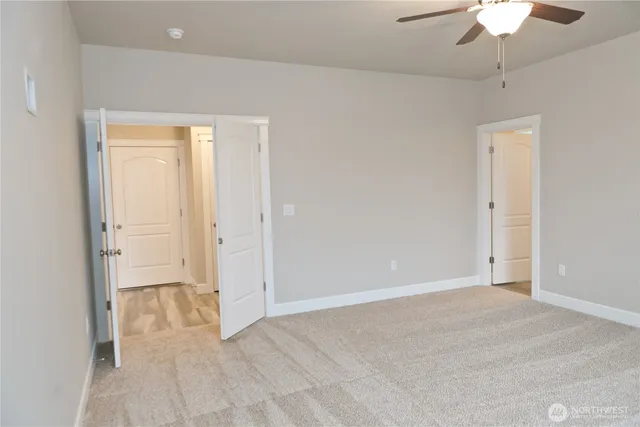a view of an empty room with a chandelier fan