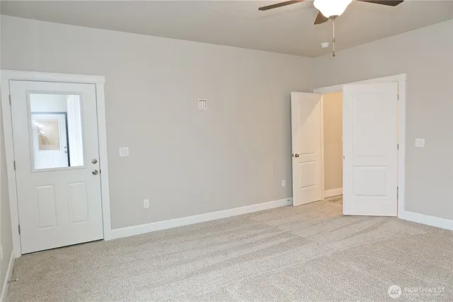 an empty room with a ceiling fan and a window