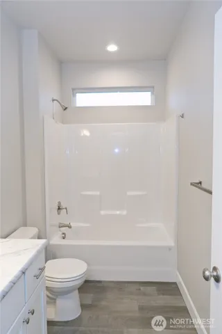 a view of an empty room with closet and a bathroom