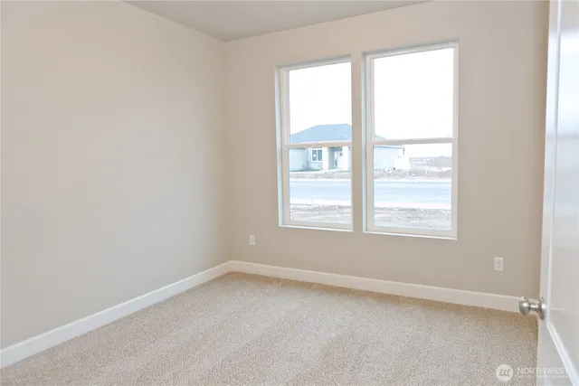an empty room with closet and a hallway
