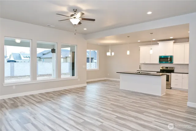 a view of large kitchen with granite countertop kitchen island stainless steel appliances refrigerator and a fireplace