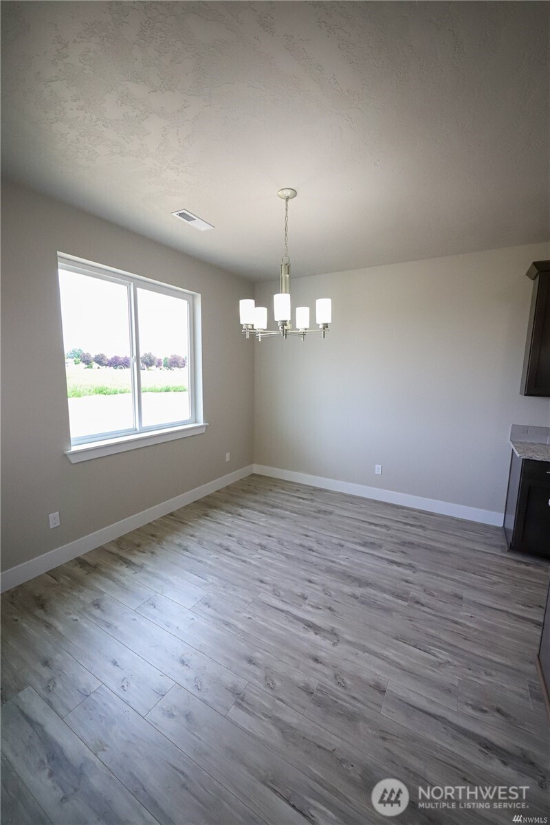 707 A Street Northeast Quincy, WA 98848 - Photo 10 of 27 an empty room with wooden floor and windows