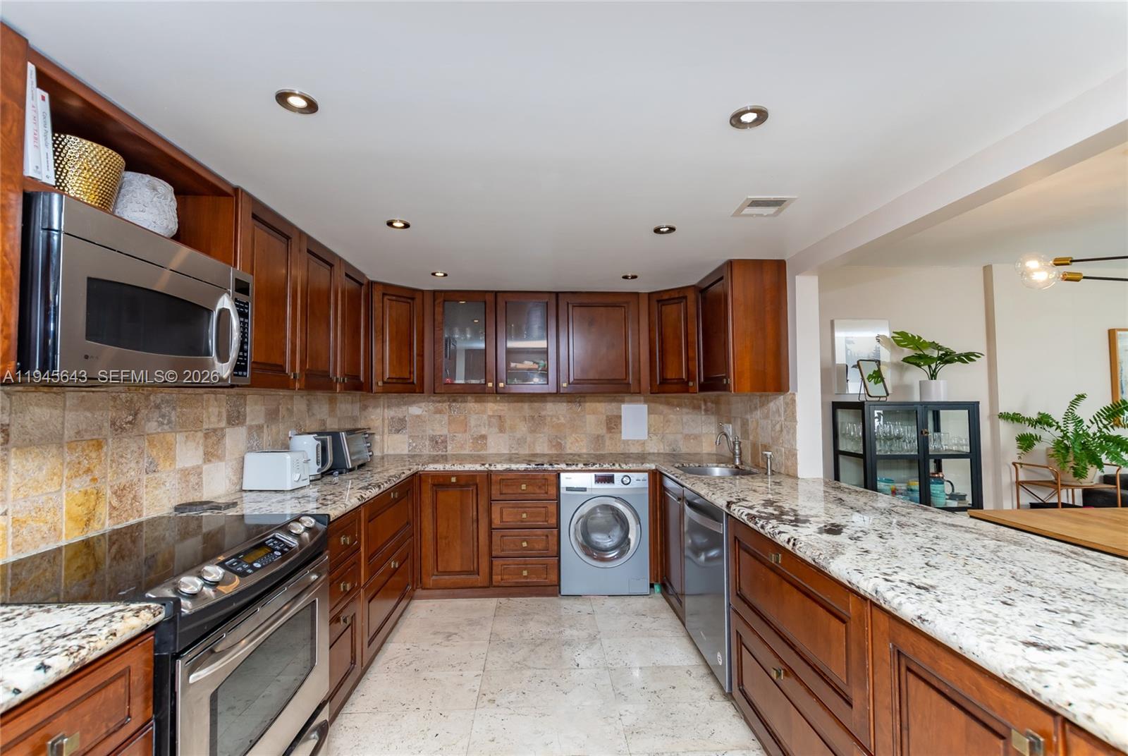 199 Ocean Ln Drive, Unit 807 Key Biscayne, FL 33149 - Photo 23 of 34 a kitchen with stainless steel appliances granite countertop a stove a sink and a microwave