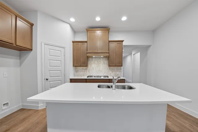 a large kitchen with stainless steel appliances granite countertop a stove a sink and a microwave