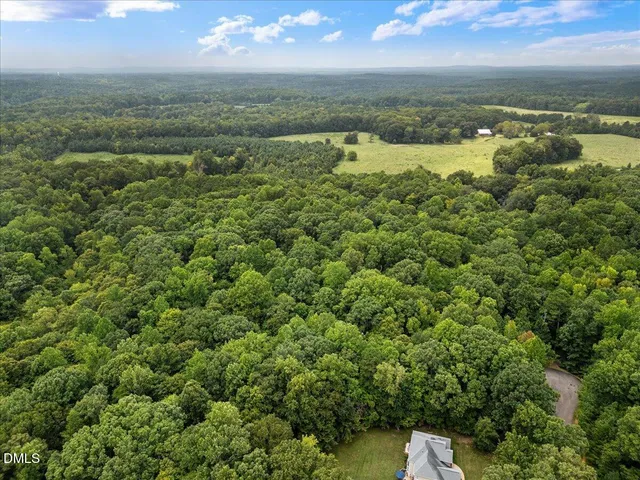 an aerial view of residential houses with outdoor space and trees