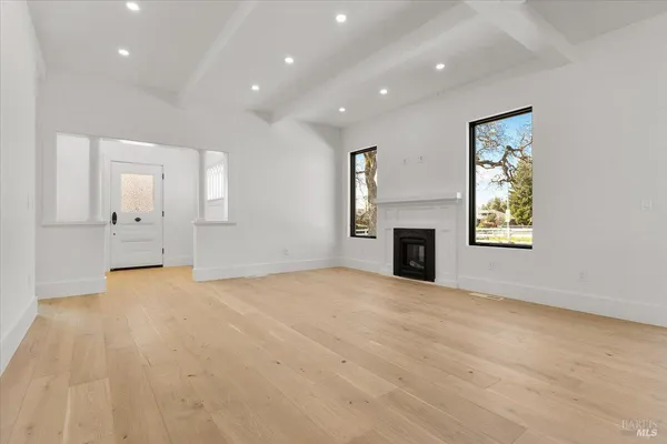 a large white kitchen with kitchen island a stove a sink a refrigerator and white cabinets