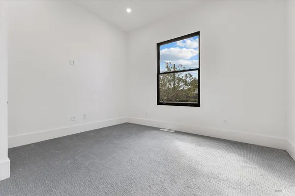an empty room with windows and ceiling fan