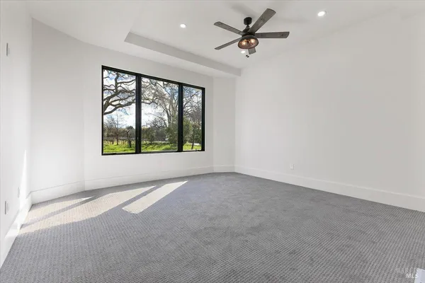 an empty room with windows and painting on the wall