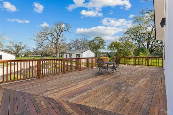 a view of backyard with wooden floor and fence
