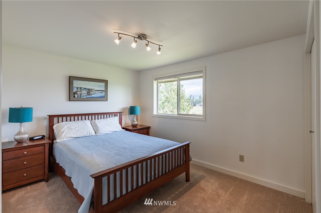 5434 Noon Road Bellingham, WA 98226 - Photo 20 of 40 a bedroom with a bed and a chandelier