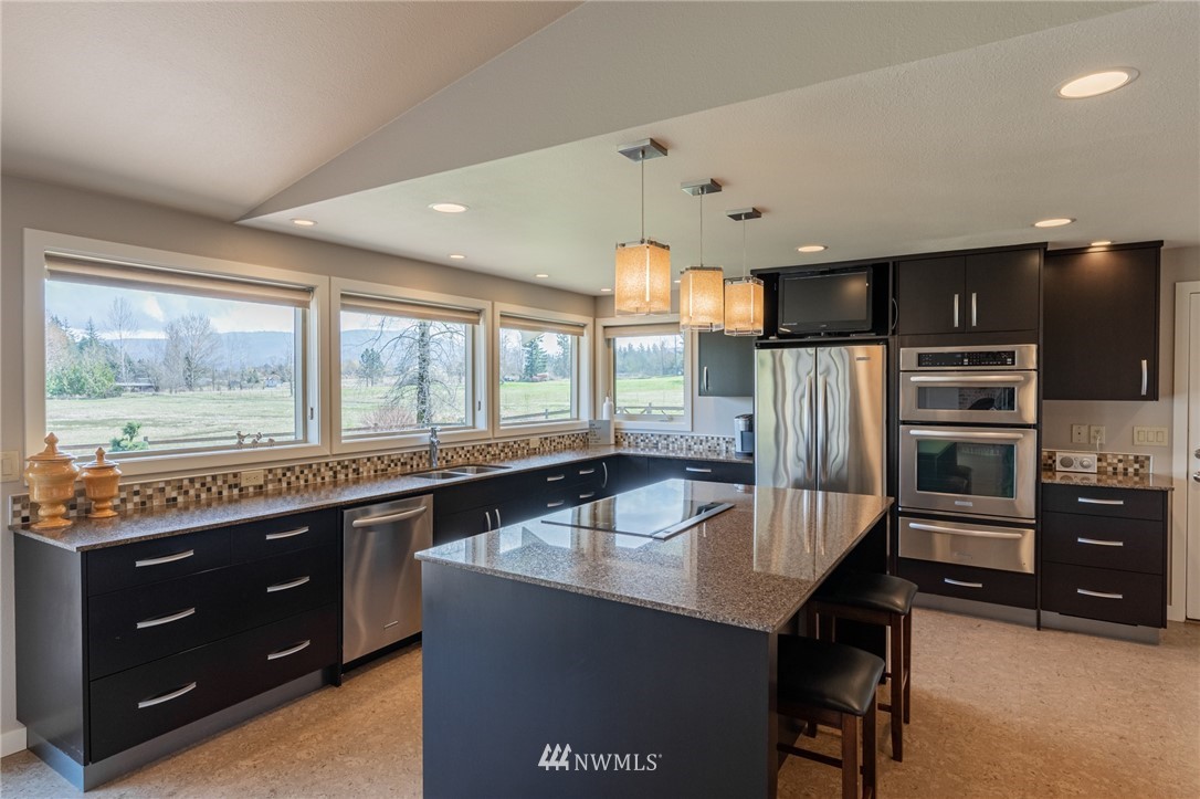 5434 Noon Road Bellingham, WA 98226 - Photo 35 of 40 a kitchen with stainless steel appliances granite countertop a sink a stove and a refrigerator