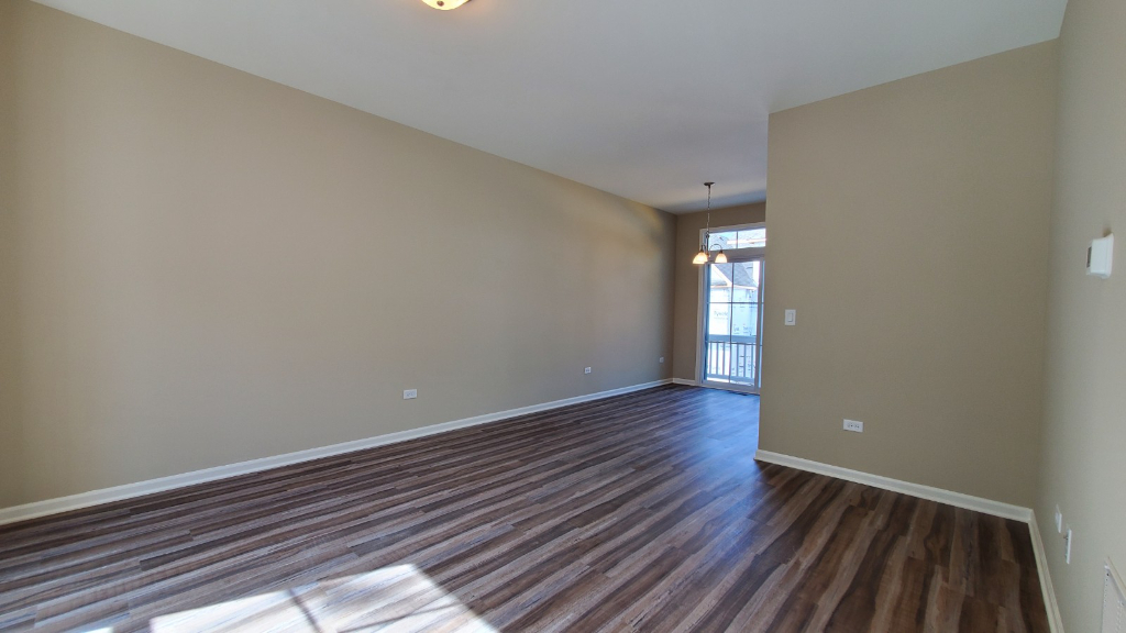 247 Timber Ridge Court Joliet, IL 60431 - Photo 8 of 16 a view of an empty room with wooden floor and a window