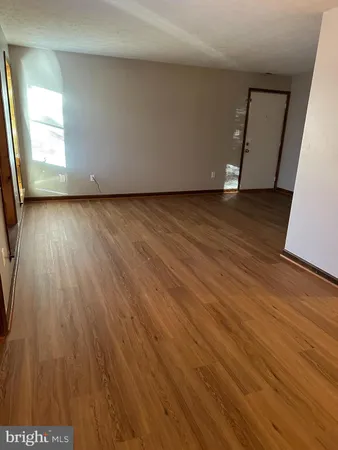 a view of room with wooden floor and staircase