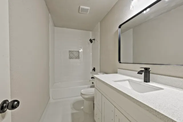 a bathroom with a sink a toilet and shower