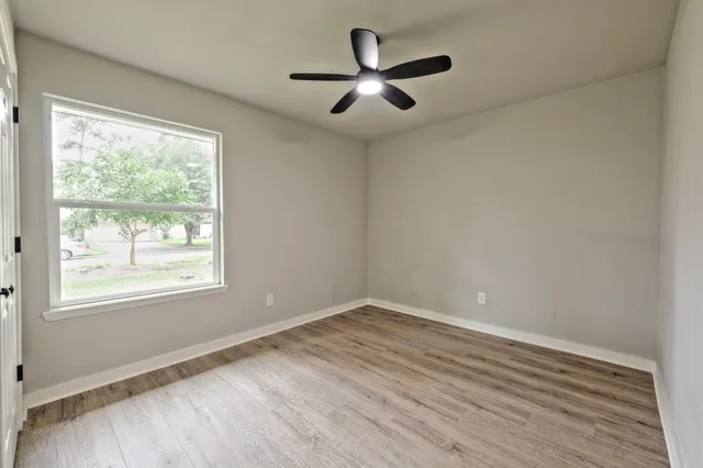 a view of a big room with wooden floor and windows