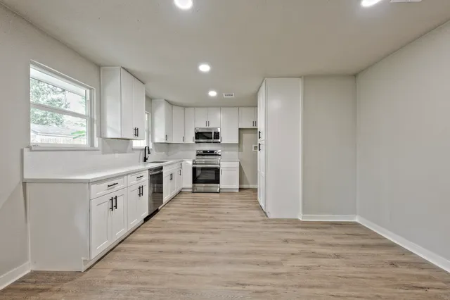 a kitchen with white cabinets and white appliances