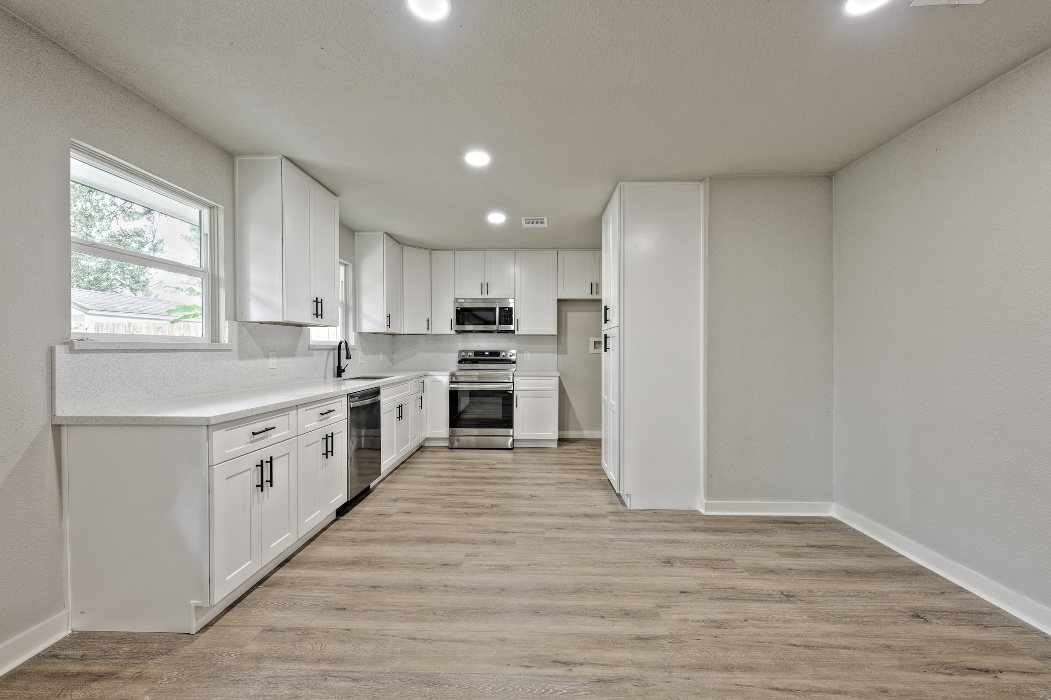 4926 Adonis Drive Spring, TX 77373 - Photo 7 of 16 a kitchen with white cabinets and white appliances
