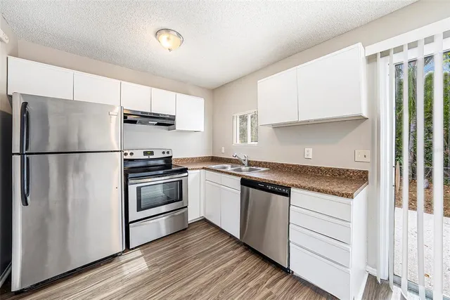 a kitchen with stainless steel appliances and white cabinets