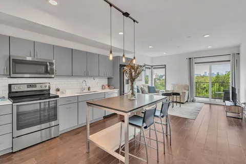a kitchen with a table chairs microwave and cabinets