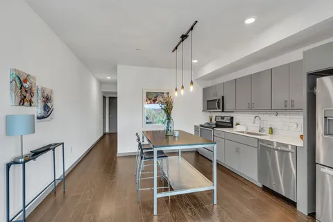 a kitchen with a table chairs refrigerator and microwave