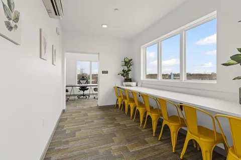 a large white kitchen with wooden floor and a sink