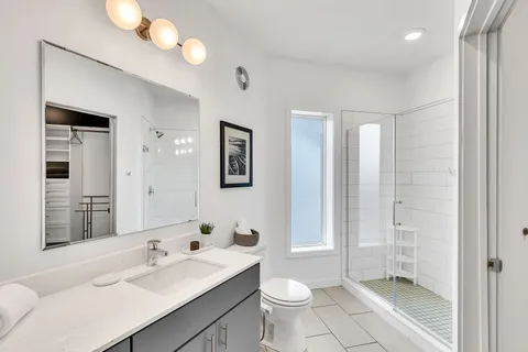 a bathroom with a sink toilet a mirror and shower